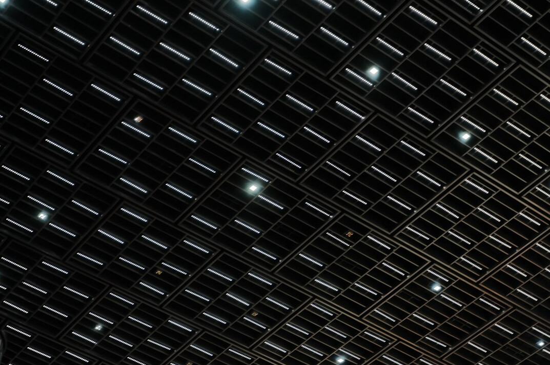 Studio lighting rig with softboxes and LED panels hanging from a ceiling grid