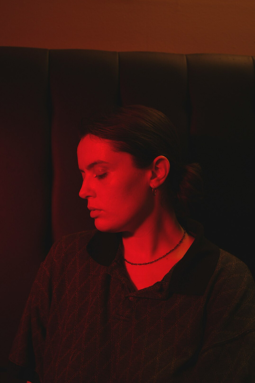 Portrait of a smiling woman sound engineer wearing headphones around her neck in a studio